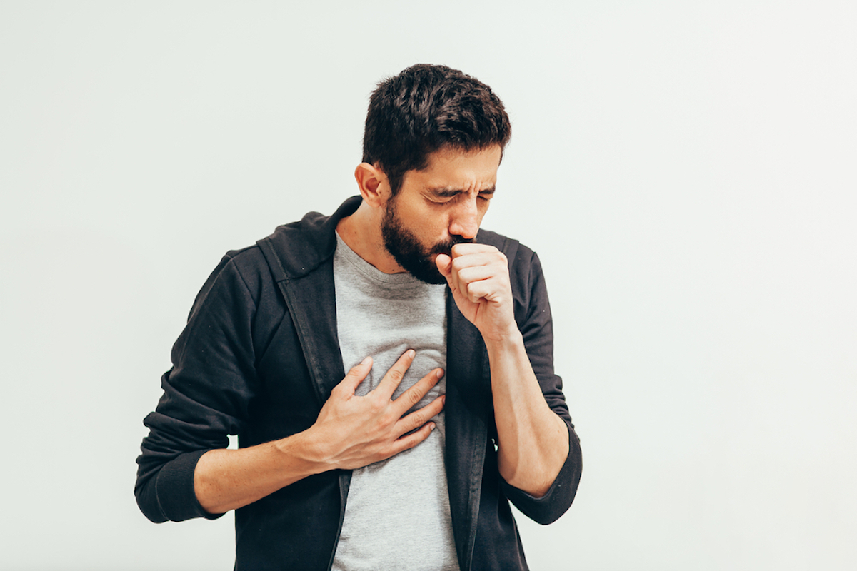 Sick man coughs over his hand. Early lung cancer symptoms