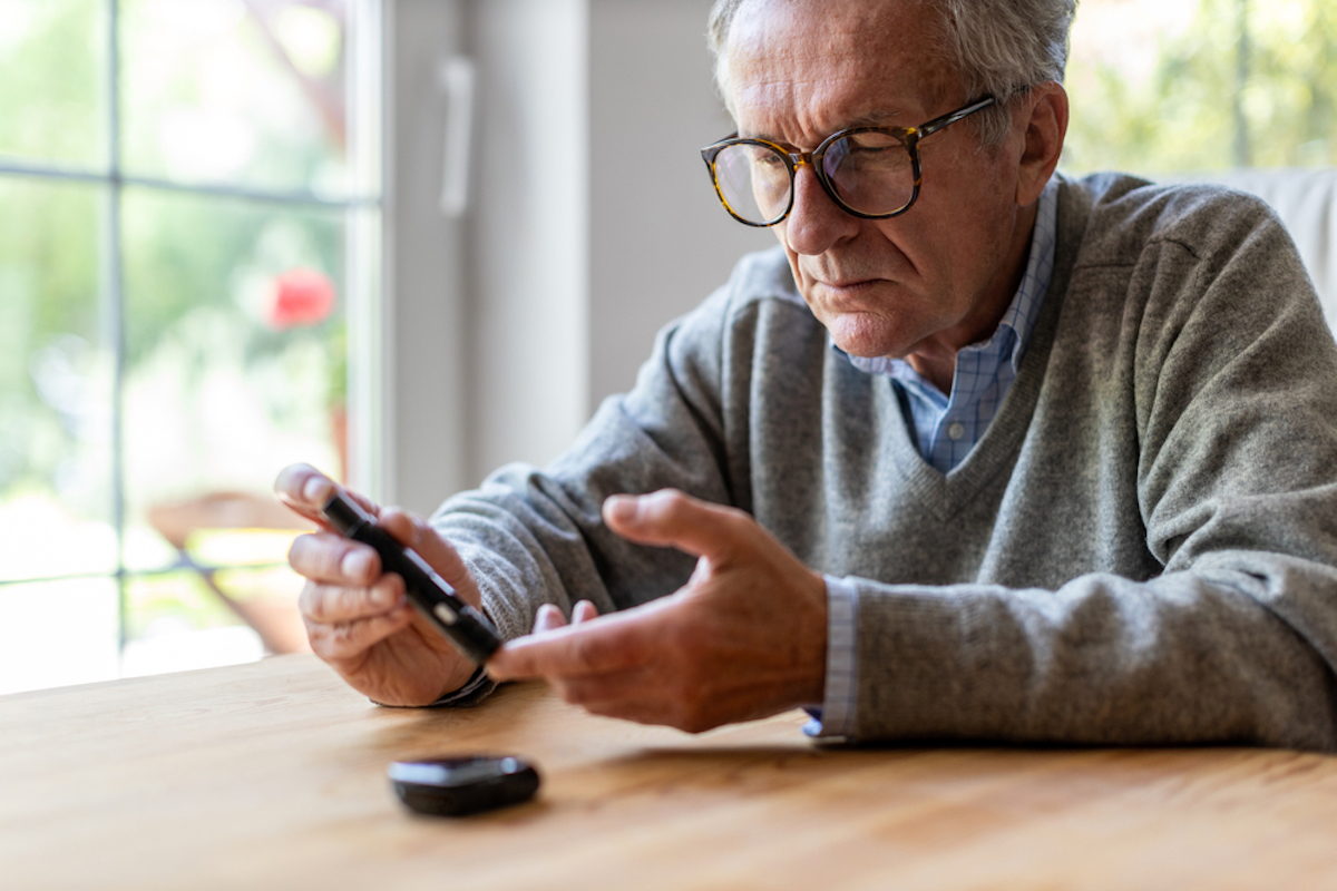 Mature Man with Diabetes Checking Blood Sugar Level With Glucometer. 