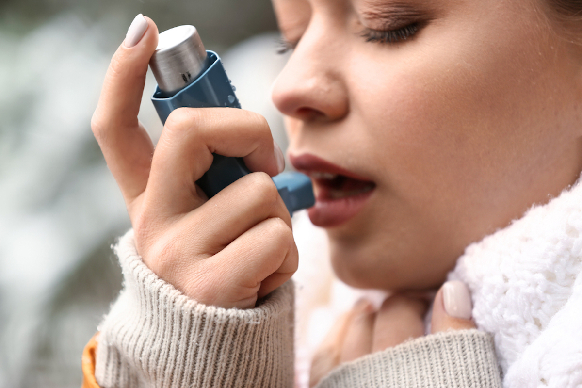 Young Woman with Inhaler Having Asthma Attack Outdoors Close up