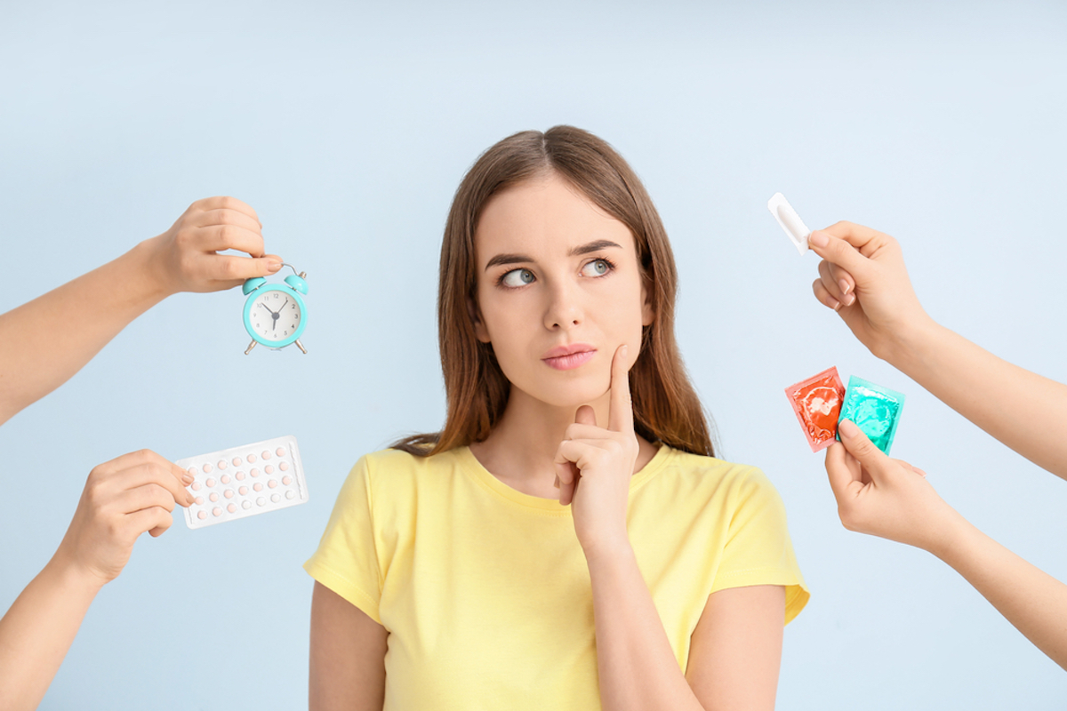 Caucasian women with brown hair, green eyes, and a yellow t-shirt thinking about different kinds of birth control