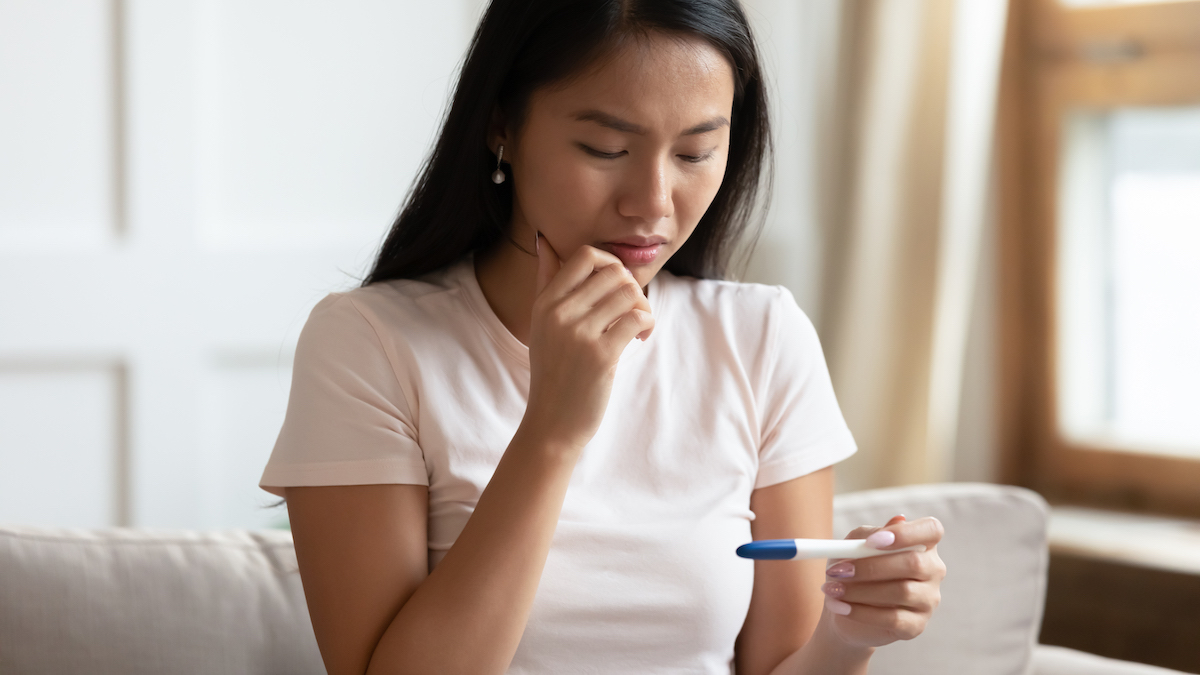 Asian woman look at a pregnancy test